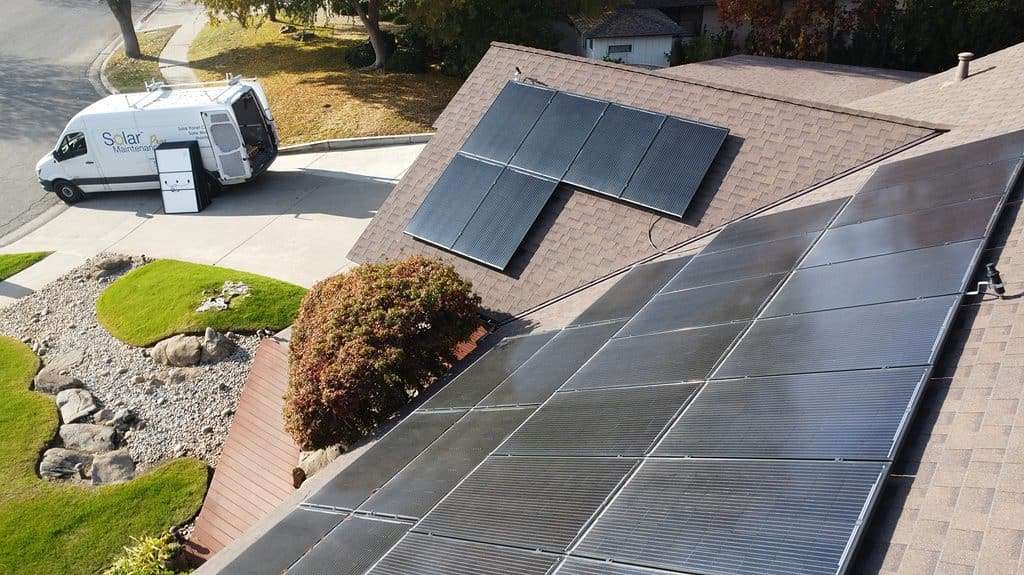 Image of rooftop with solar panels and Solar Negotiators van.