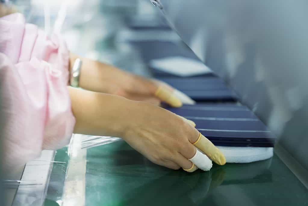 Worker in solar panel assembly factory.