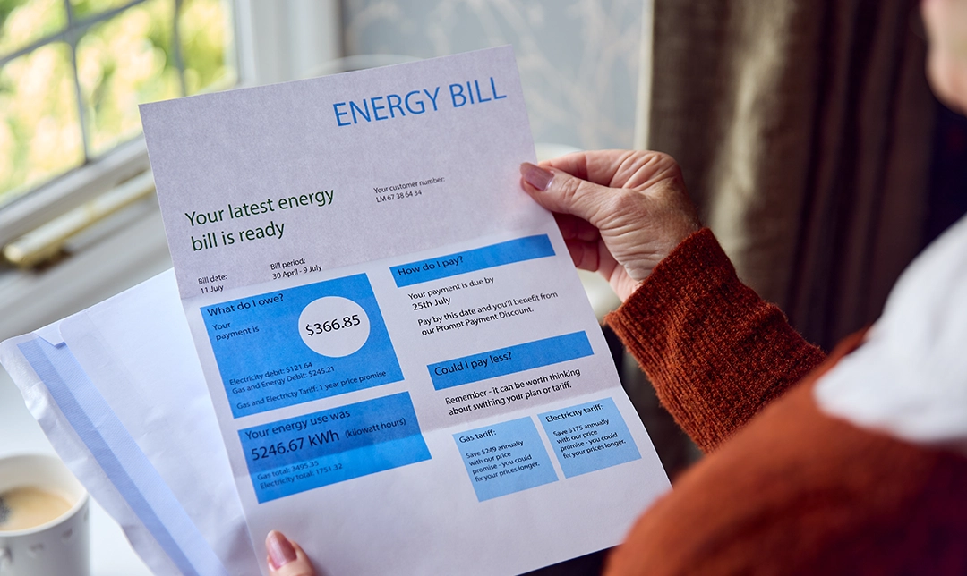 woman opening energy bill and reviewing charges